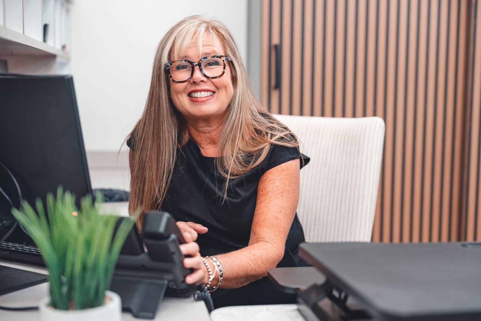 A smiling team member at the erth. dental front desk
