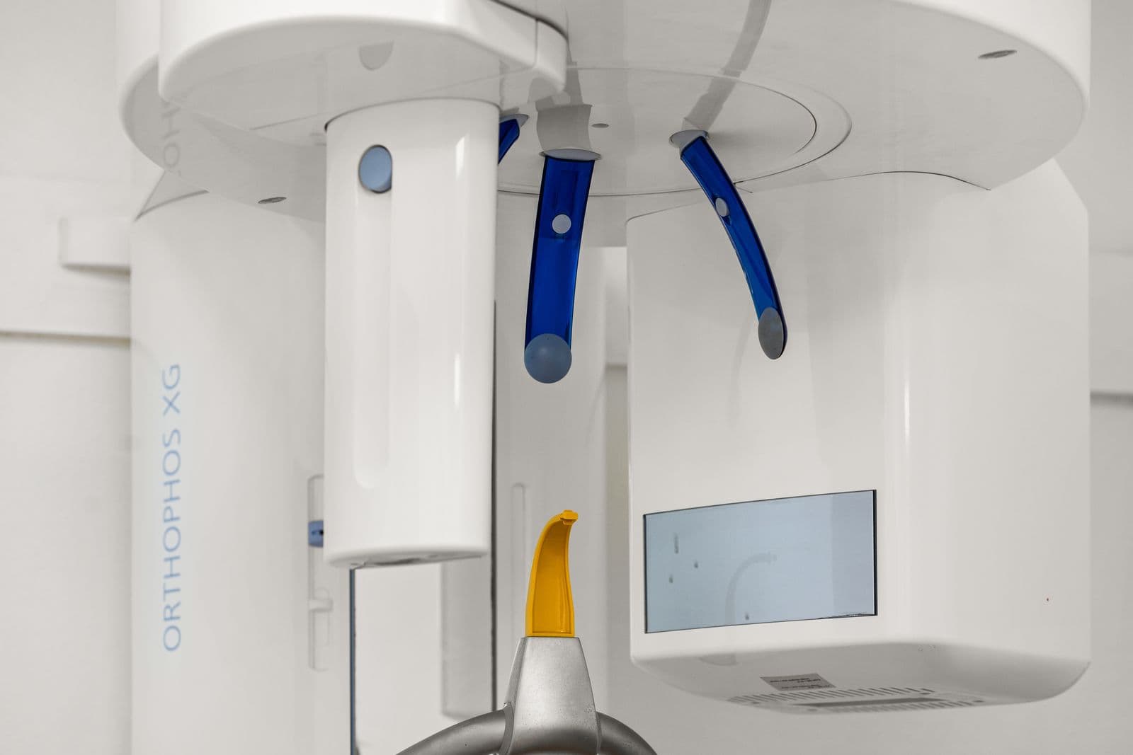 A close view of the Orthophos XG imaging unit with its blue positioning arms and bite block