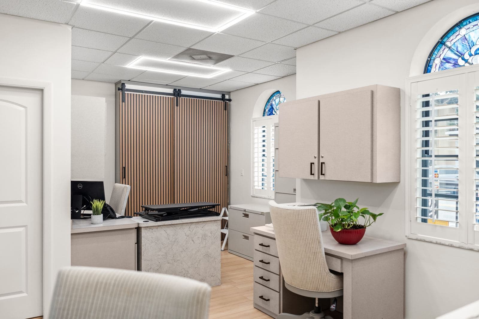 A bright planning office at erth. dental with an arched stained glass window